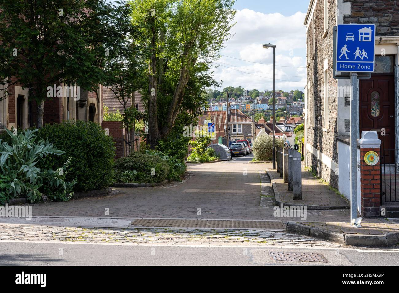 Straßenbäume und Sträucher tragen in einer Wohnstraße in Bristol zur Beruhigung des Verkehrs und zur Widerstandsfähigkeit des Klimas bei. Stockfoto
