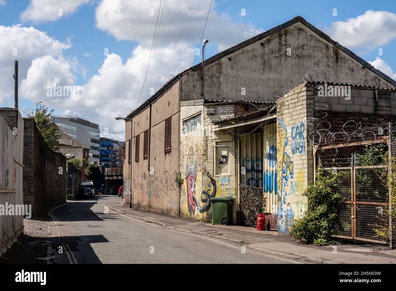 Heruntergekommenen und verkommenen leichten Industriegebäuden entlang der Gas Lane, die Teil eines städtischen Sanierungsgebiets in Bristol ist, mit modernen Bürogebäuden der TEM Stockfoto