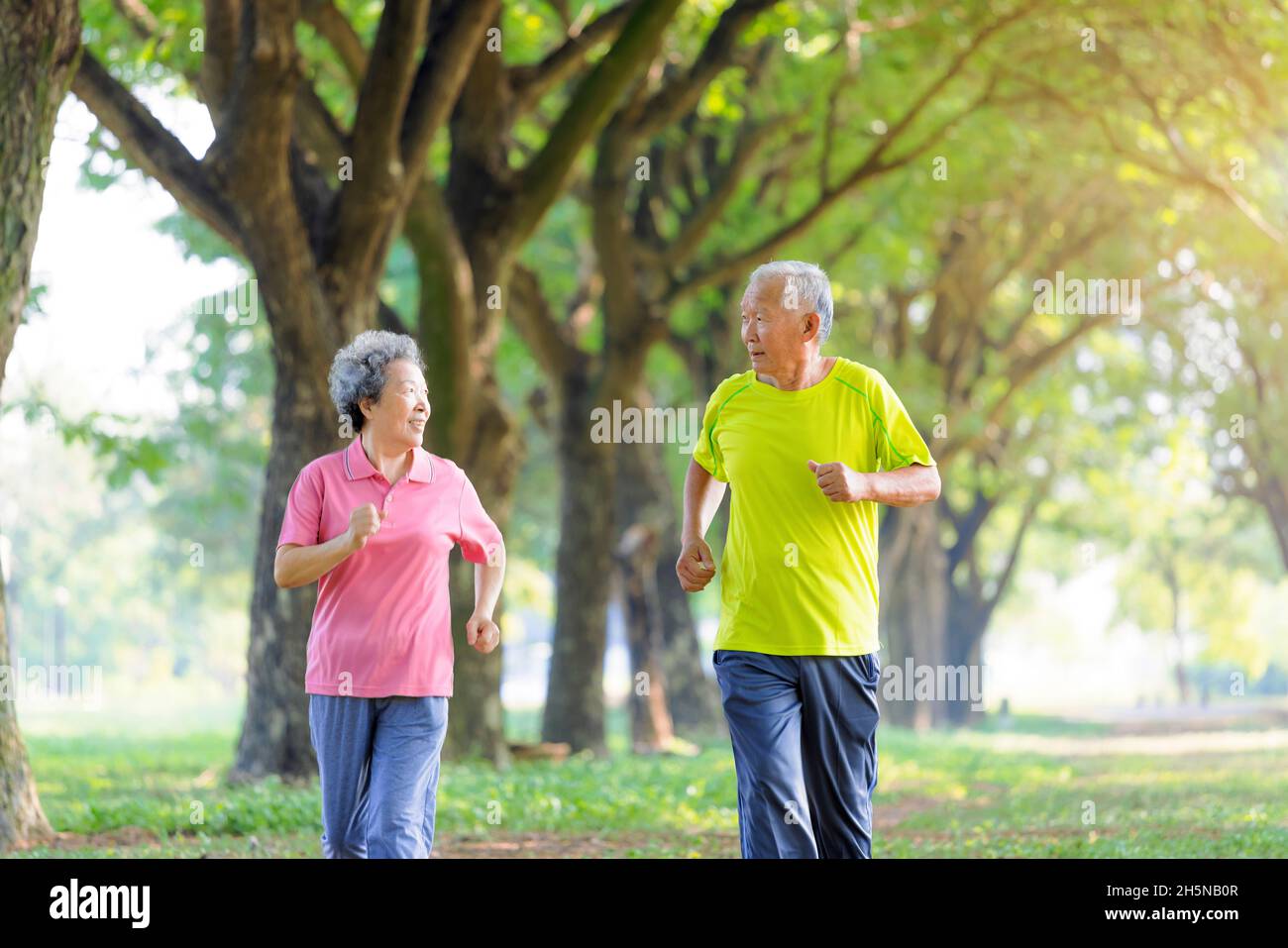 Asiatisches Seniorenpaar beim Joggen im Park Stockfoto