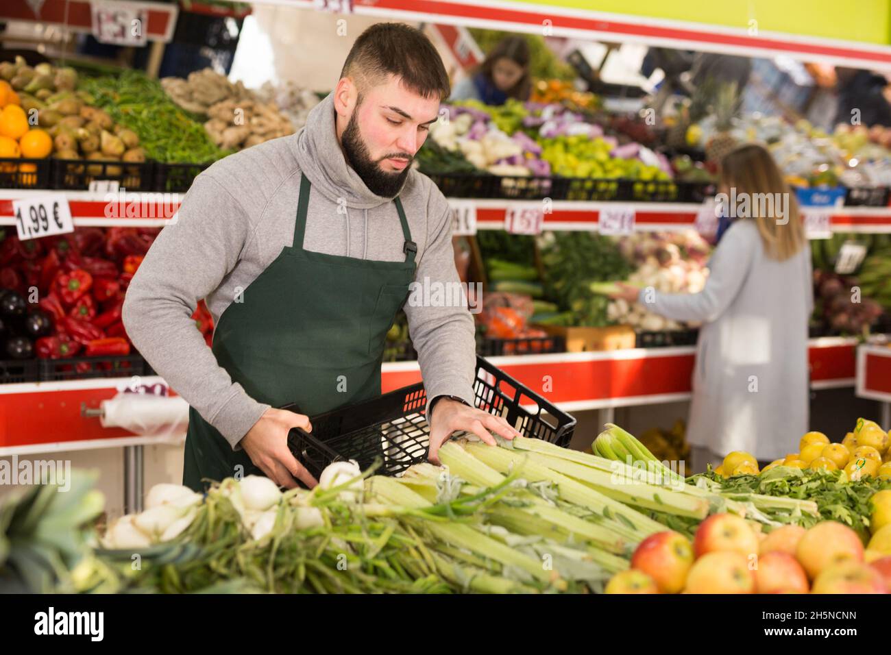 Einkaufsassistent legt Gemüse und Obst an die Theke des Supermarkts Stockfoto