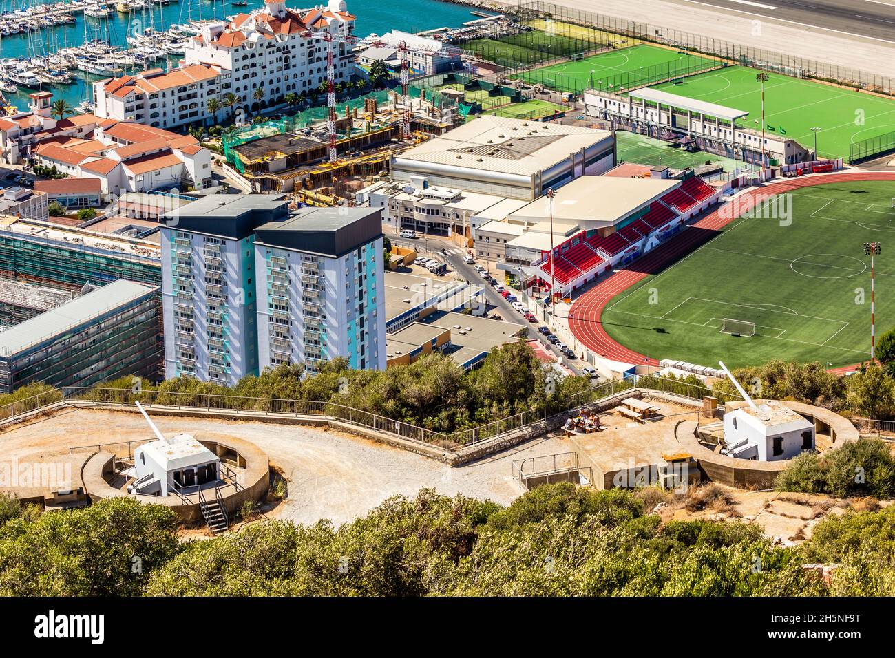 Blick auf die Stadt Gibraltar vom Felsen von Gibraltar mit Artilleriebüssen und Fußballplatz im Vordergrund Stockfoto