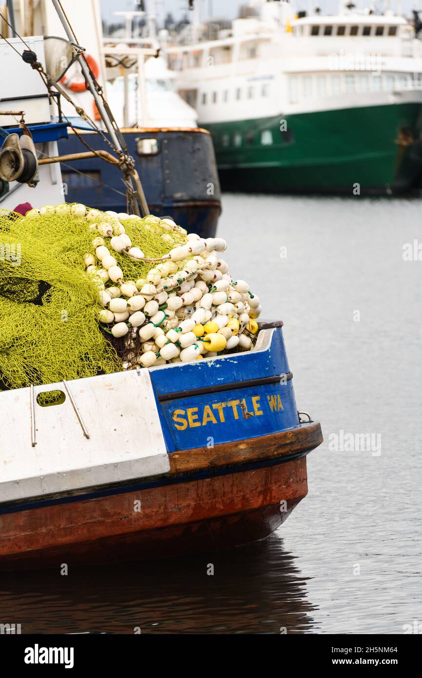 Seattle - 09. November 2021; Ein Fischerboot mit Seattle WA in Gold auf blauem Heck. Fischernetze und Schwimmer werden hoch auf dem Schiff angehäuft Stockfoto