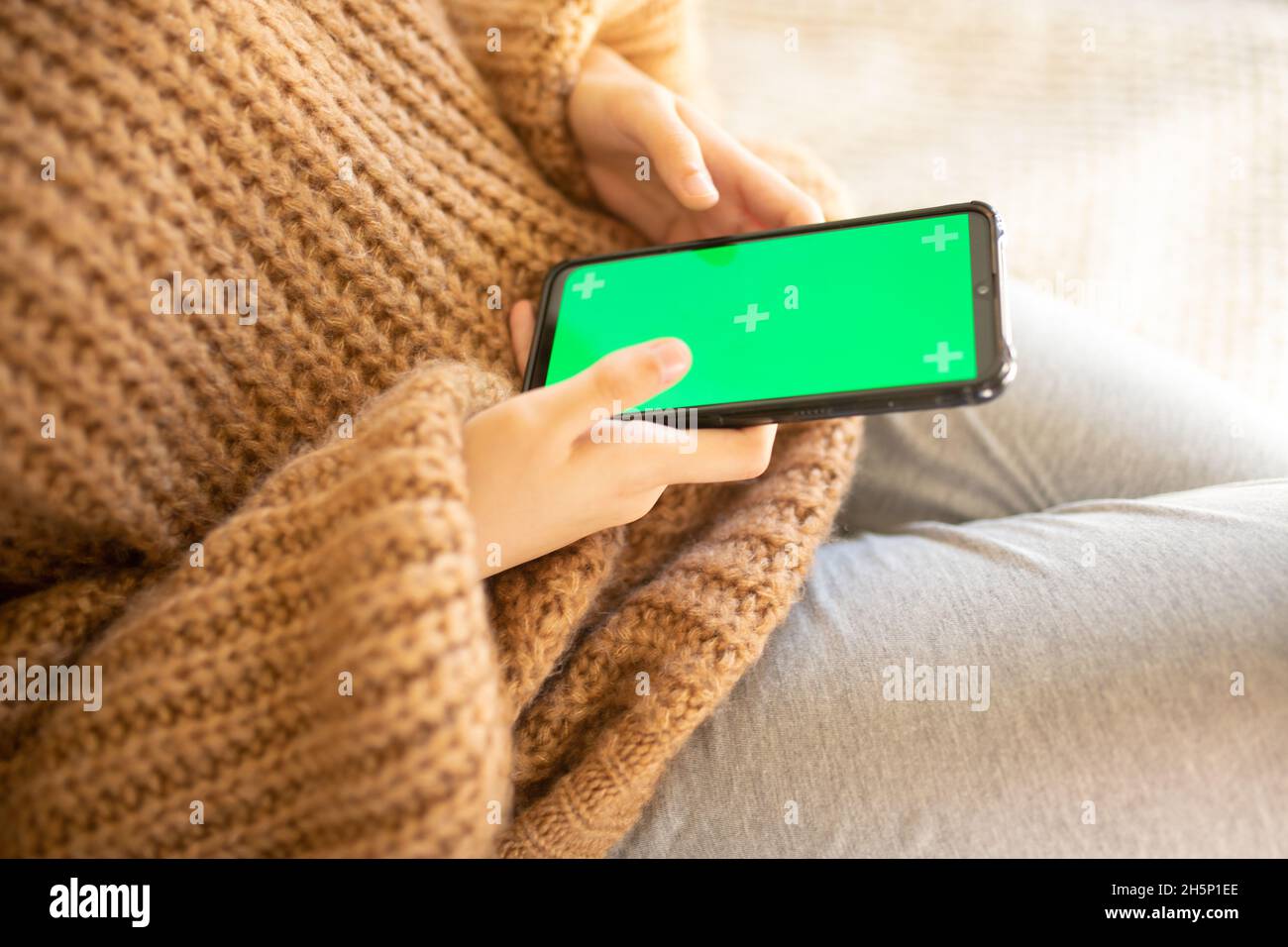 Mädchen mit Smartphone mit Chroma-Key-Bildschirm Stockfoto