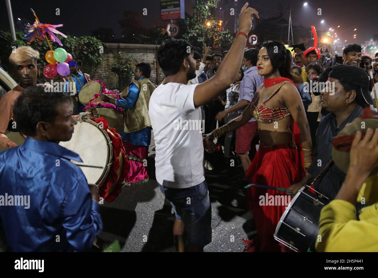 Kalkutta, Indien. November 2021. Ein indischer Eunauch tanzt, während sich eine hinduistische Anhängerin während des Chhath-Festivals auf dem Boden niederlässt, während sie in Richtung des Ganges in Kalkutta weitergeht. 'Chhath' bezeichnet die Zahl 'Six' und das Fest beginnt am sechsten Tag des Hindu-Monats 'Kartik' im Hindu-Mondkalender, entsprechend Ende Oktober und Mitte November, je nach Jahr. Es ist eines der heiligsten Festivals für Biharis und erstreckt sich über vier Tage. (Foto: Dibakar Roy/Pacific Press) Quelle: Pacific Press Media Production Corp./Alamy Live News Stockfoto