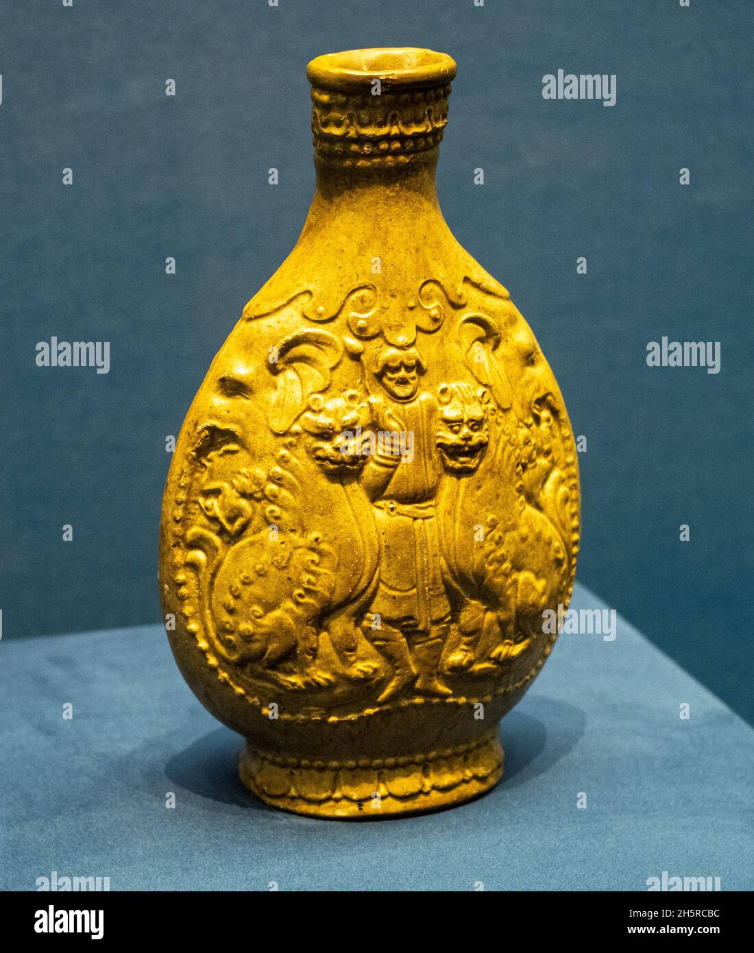 Grün glasierte flache hu mit Ausländern, die Löwen tanzen. Nördliche Qi-Dynastie, 550-577 u.Z. In der Sammlung des Shanxi Museums. Stockfoto