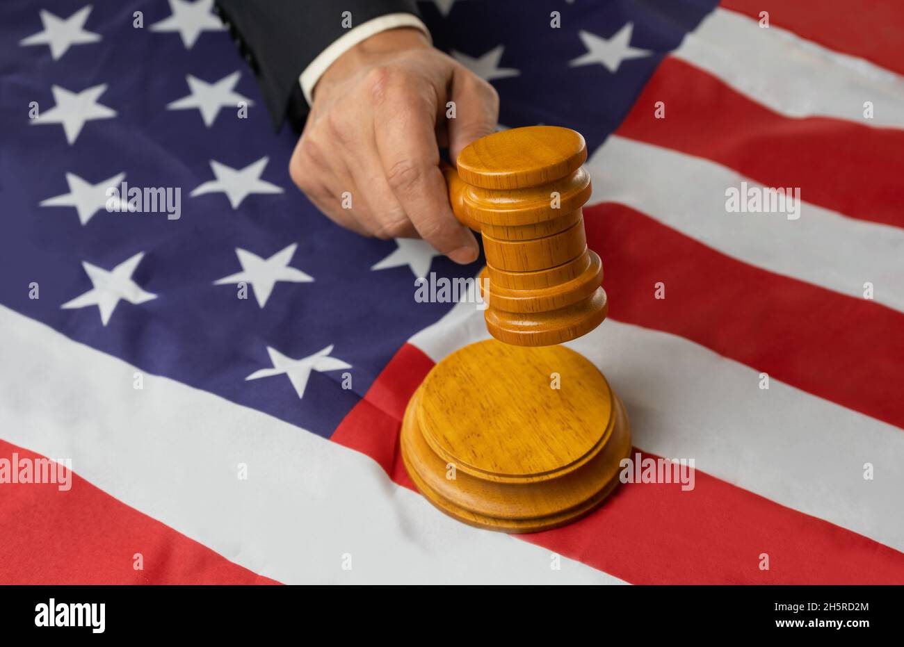 Mann Richter Hand hält Holzgavel auf klingenden Block auf usa Flagge Hintergrund Knall.Justice Konzept mit vereinigte Staaten von amerika Flagge Stockfoto