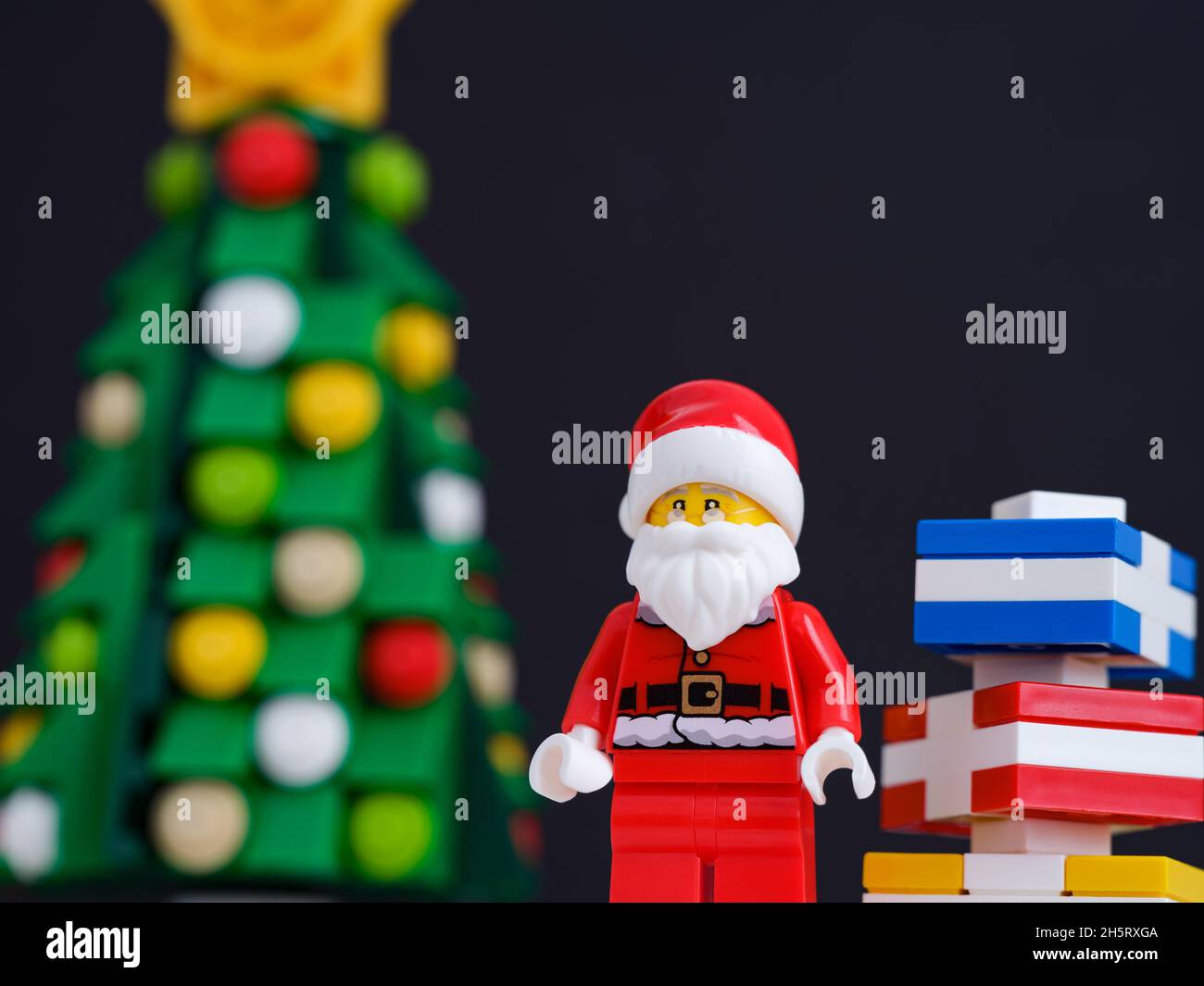 Tambow, Russische Föderation - 10. November 2021 Lego Santa Claus Minifigur mit Geschenken in seiner Nähe, die neben einem weihnachtsbaum stehen. Nahaufnahme. Stockfoto