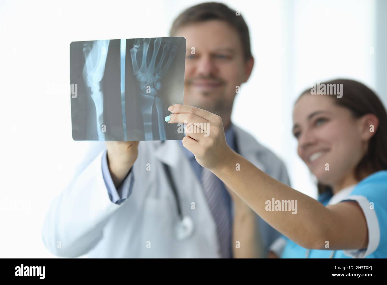 Ärzte betrachten den Röntgenstrahl der Hand in der Klinik Nahaufnahme Stockfoto