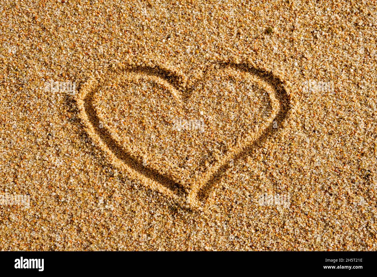 Herzzeichen auf Sand in Abendsonne geschrieben Stockfoto