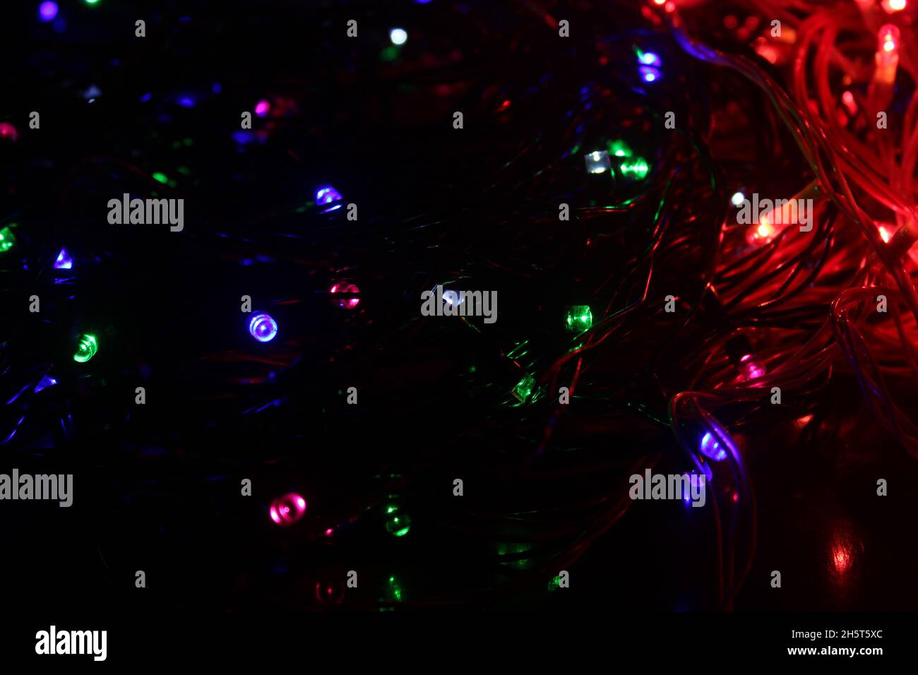Abstrakter Hintergrund mit farbenfrohen LED-Leuchten, die im Dunkeln leuchten Stockfoto
