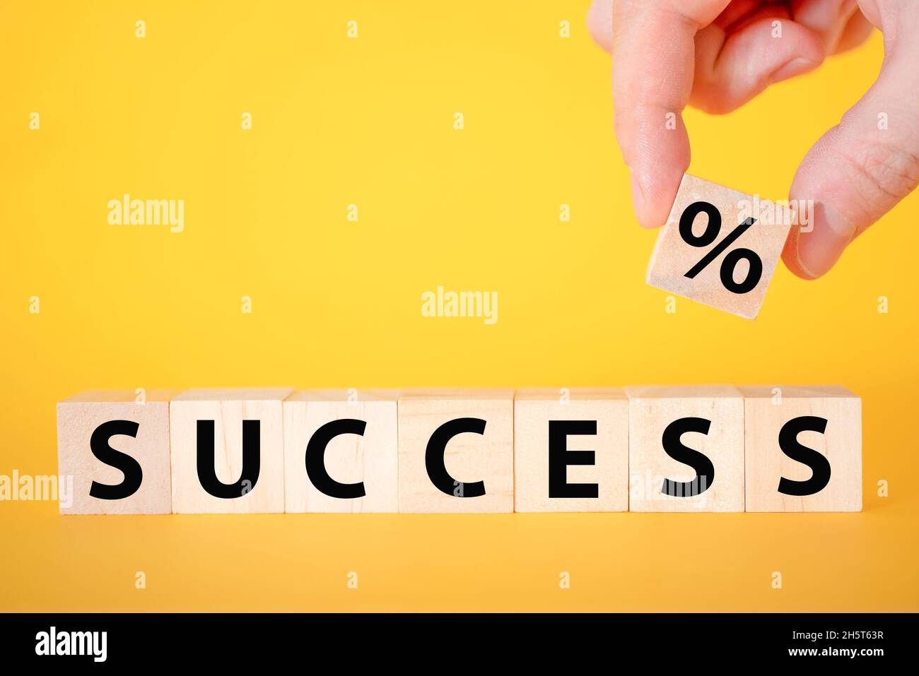 Der Erfolg des Textes auf einem gelben Hintergrund aus Holzwürfeln. Geschäftswachstum in der Teamarbeit. Stockfoto