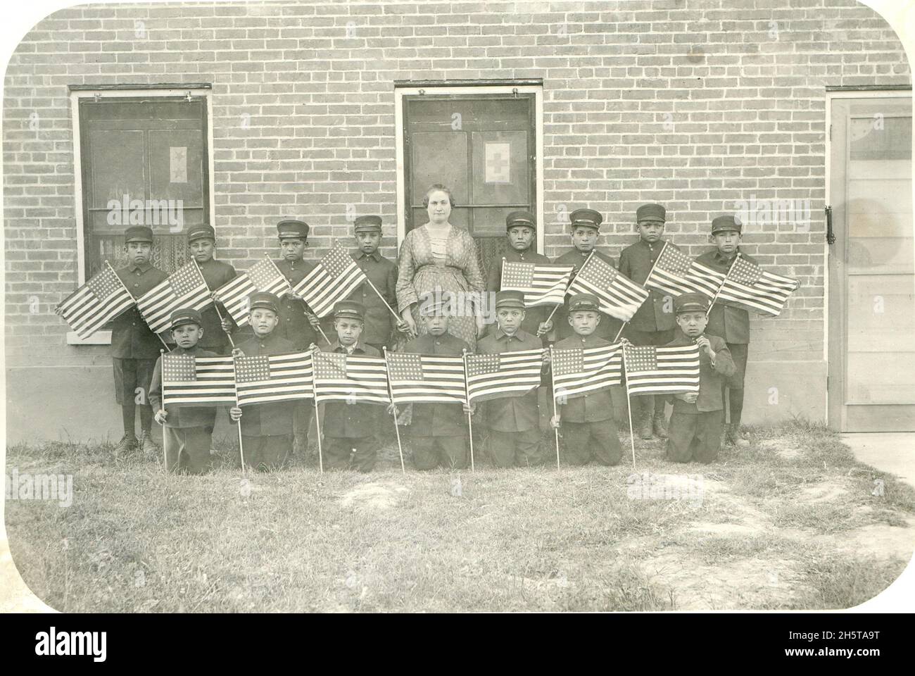 Blick auf Jungen und ihre Lehrer von der Albuquerque Indian School, Ende der 1890er oder Anfang der 1900er Jahre. Jungs mit amerikanischen Flaggen. Stockfoto