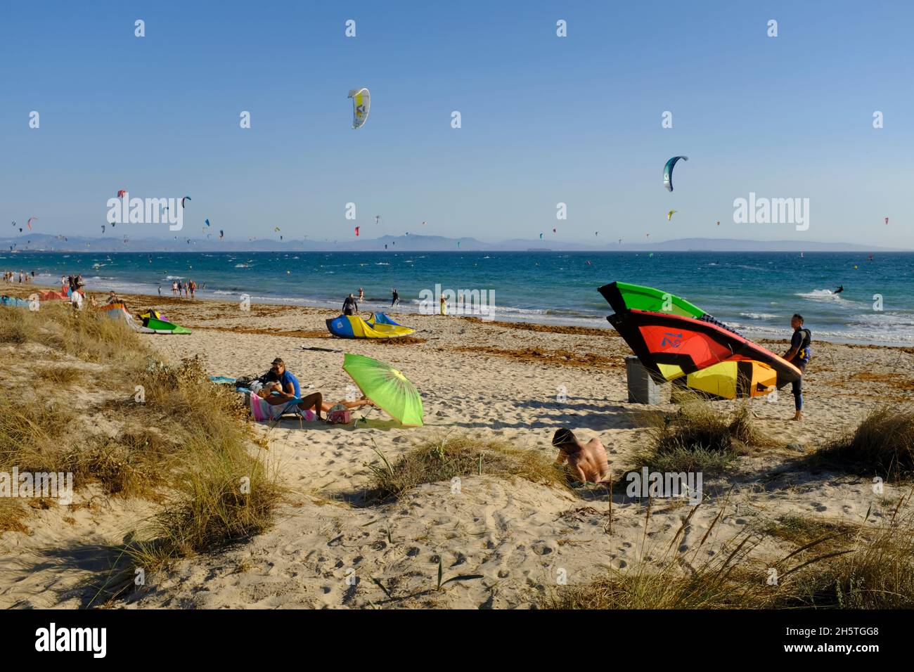 Kitesurfer, die ihre Drachen und Sonnenanbeter am Strand von Los Lances vorbereiten.Tarifa, Costa de la Luz, Provinz Cadiz, Andalusien, Spanien Stockfoto