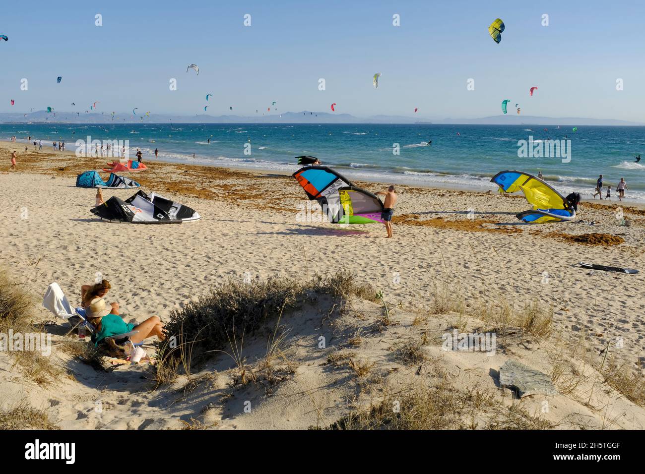 Kitesurfer bereiten ihre Drachen und Sonnenanbeter am Strand von Los Lances vor.Tarifa, Costa de la Luz, Provinz Cadiz, Andalusien, Spanien Stockfoto