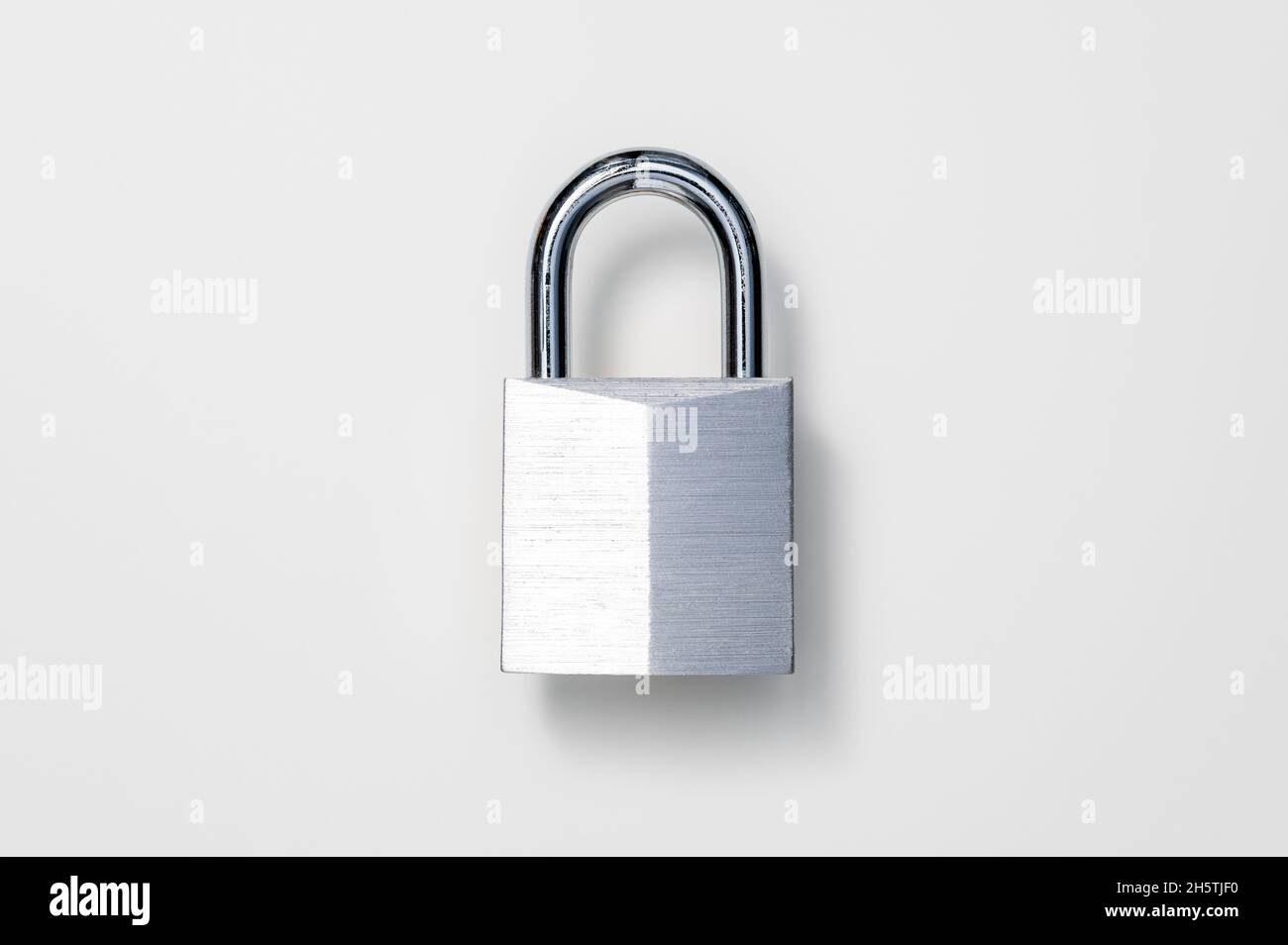Sicherheits-, Schloss- oder Diebstahlschutzkonzept. Glänzendes, vernickeltes massives Messingvorhängeschloss vor weißem Hintergrund. Tischansicht, flach liegend, Kopierbereich. Stockfoto