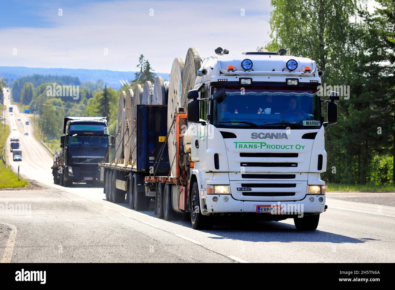 Scania R und Volvo FH LKW von Trans-Product Oy transportieren REKA Stromkabeltrommeln, gesichert mit Ketten zum Anhänger. Ikaalinen, Finnland. 12. August 2021 Stockfoto
