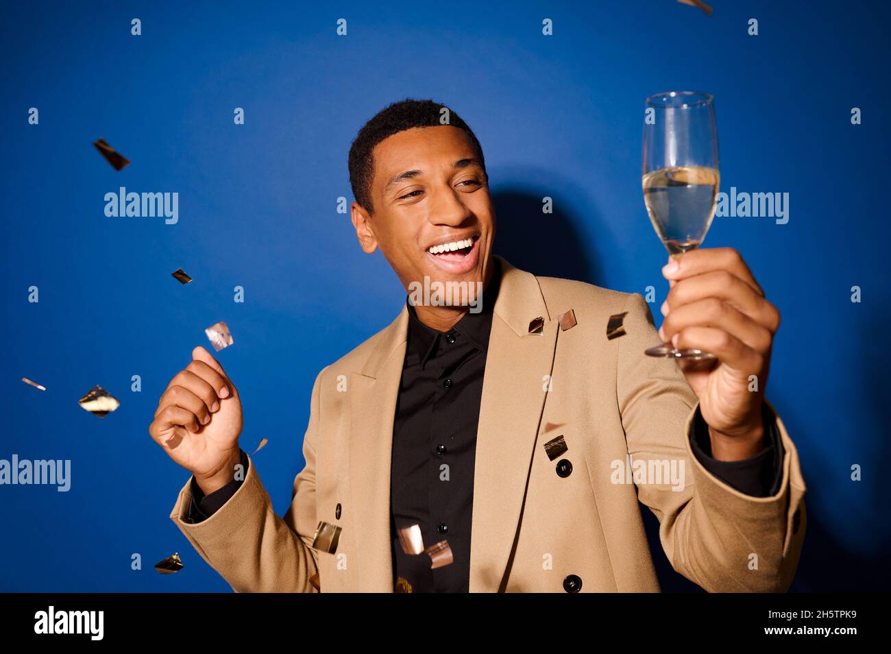Ein gut aussehender junger Mann mit einem Glas Champagner Stockfoto