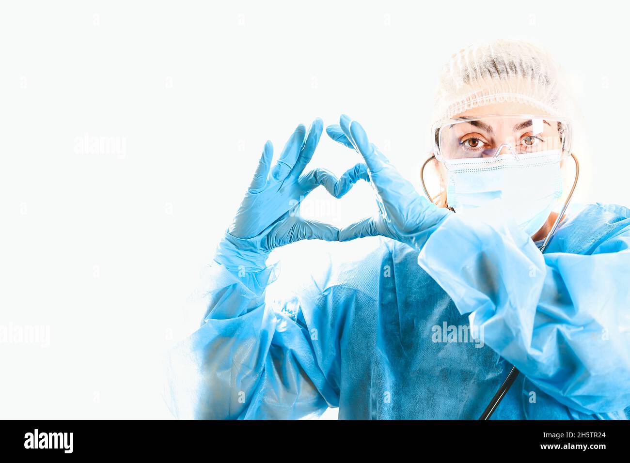 Ärztin zeigt Herz mit Händen. Die Liebe des Arztes zu den Patienten. Arzt für das Herz. Konzept der Covid-19-Quarantäne. Medizinisches Konzept. Stockfoto