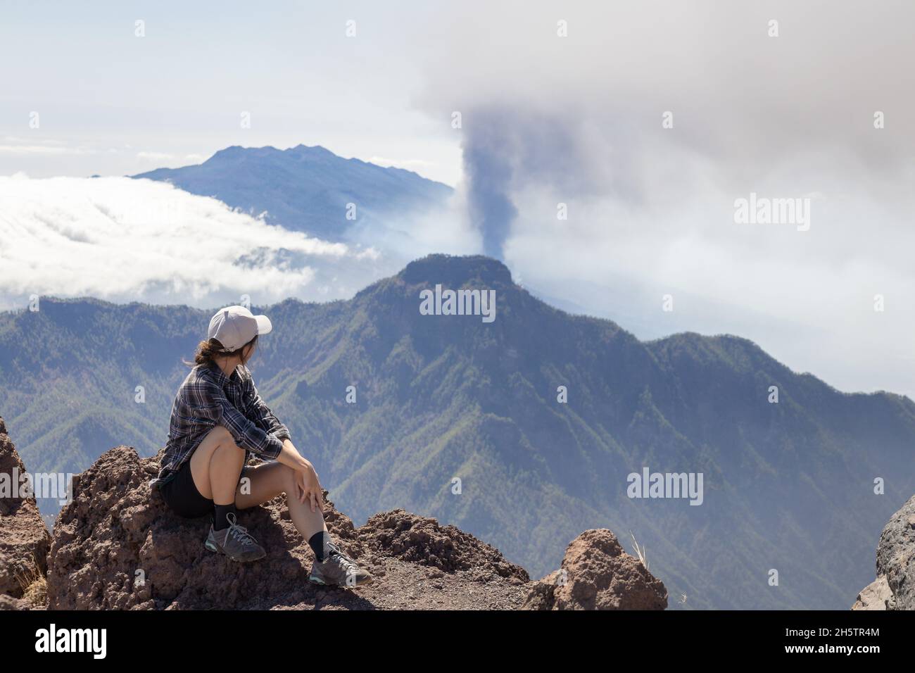 Tourist girl watching Cumbre Vieja vulkanischen Ausbruch auf der Insel La Palma, Kanarische Inseln. Vulkan La Palma aus der Ferne. Stockfoto
