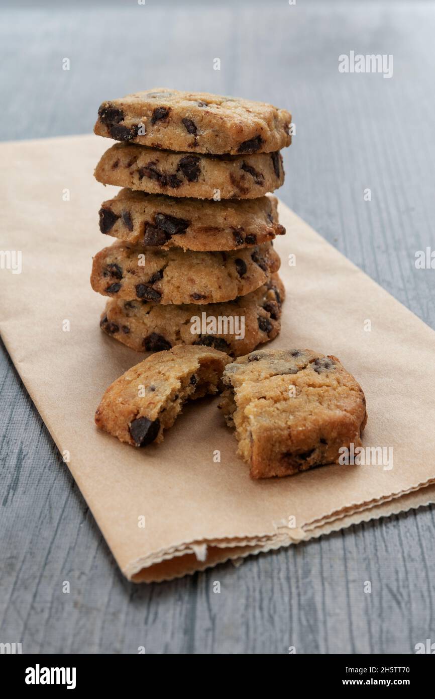 Kekse mit dunklen Schokoladenstückchen auf rustikalem Hintergrund Stockfoto