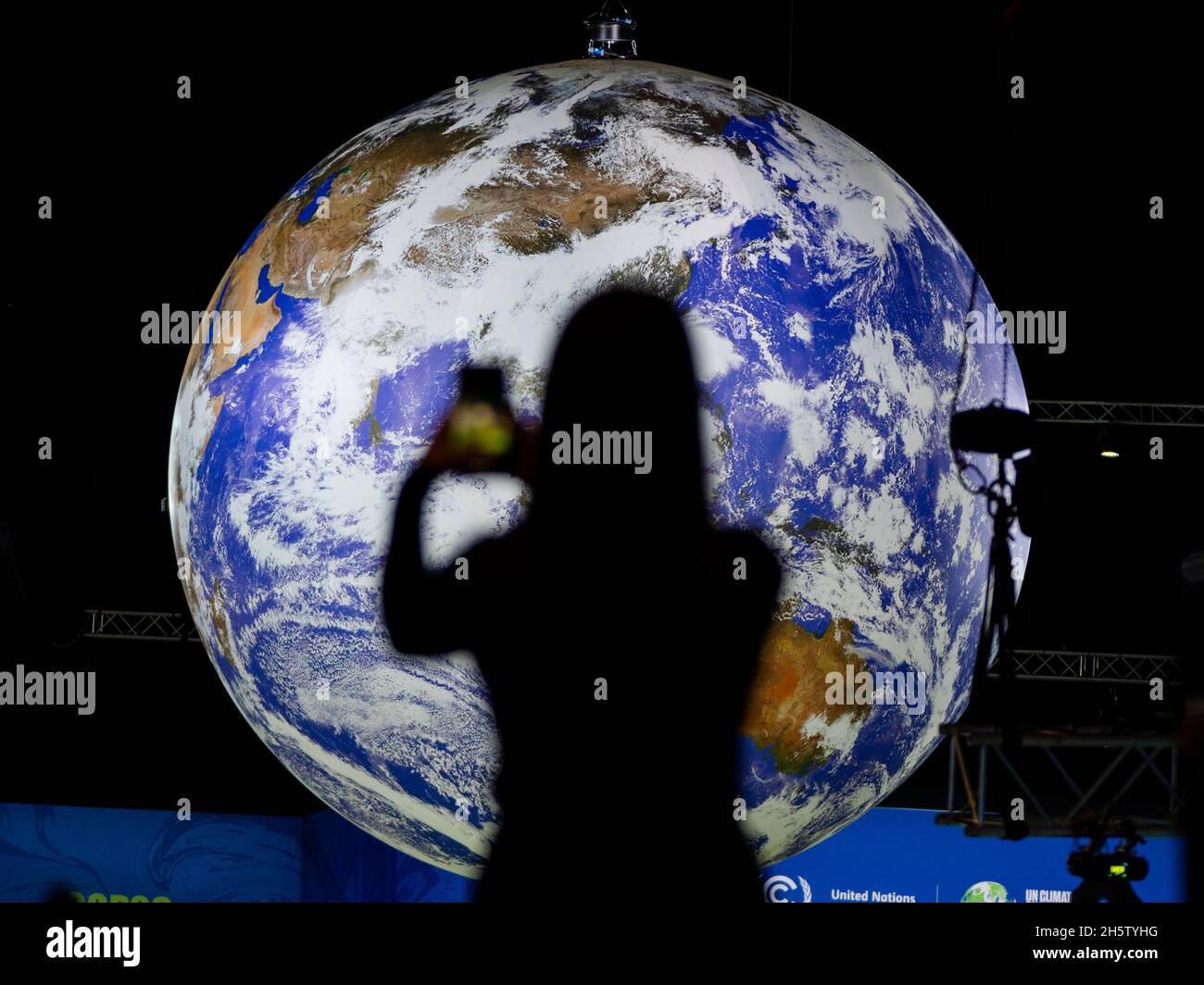 Glasgow, Schottland, Großbritannien. November 2021. Tag zwölf des Klimagipfels um COP26 in Glasgow. PIC; Delegierter macht ein Foto, das vor einem großen Globus im Aktionsbereich steht. Iain Masterton/Alamy Live News. Stockfoto