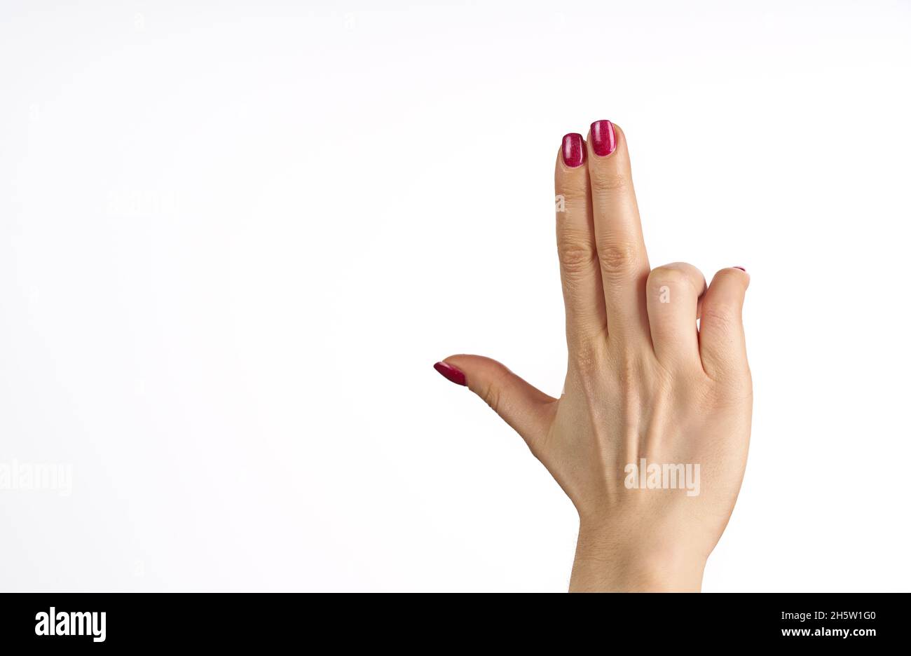 Die Hand der Frau, die Schusswaffe, Geste. Handpistole Geste auf isoliertem weißen Hintergrund. Frau Hand zeigt mit zwei Fingern. Stockfoto