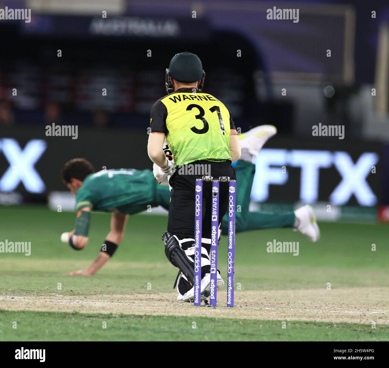 Dubaii, VAE, 11, Nov 2021: ICC T20 2. Halbfinale: Pakistan gegen Australien: Afridi von Pakistan versucht, seinen eigenen Ball vor dem Hit von Warner in Aktion während der 2. Halbzeit im Dubai interraational Stadium am Donnerstag zu stoppen. Bildnachweis: Seshadri SUKUMAR Kredit: Seshadri SUKUMAR/Alamy Live Nachrichten Stockfoto