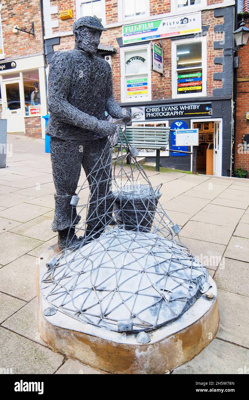 Eine Drahtskulptur der lokalen Künstlerin Emma Stothard eines Fischers, der Netze in Whitby North Yorkshire repariert Stockfoto