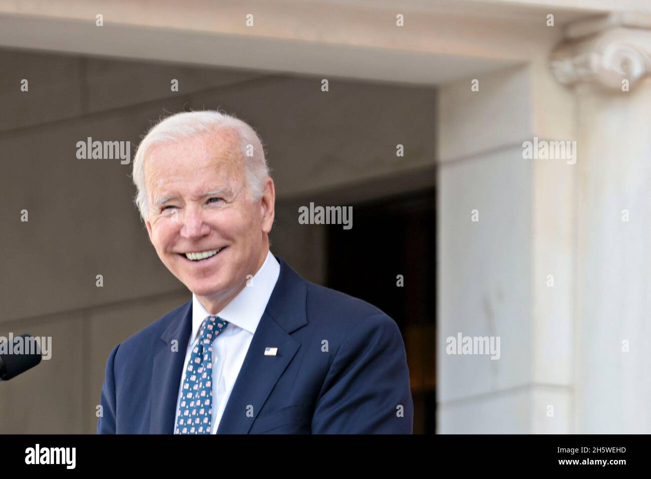 Arlington, Virginia, USA. November 2021. Der Präsident der Vereinigten Staaten, Joe Biden, lächelt während einer Rede bei der Zeremonie zur Einhaltung des National Veterans Day im Memorial Amphitheatre auf dem Arlington National Cemetery in Arlington, Virginia, USA, am Donnerstag, den 11. November, 2021. 2021 jährt sich zum hundertsten Mal das Grab des unbekannten Soldaten, das eine letzte Ruhestätte für eines der nicht identifizierten Dienstmitglieder des Ersten Weltkriegs in Amerika darstellt, und 1958 und 1984 wurden Unbekannte aus späteren Kriegen hinzugefügt. Quelle: Oliver Contreras/Pool via CNP/dpa/Alamy Live News Stockfoto