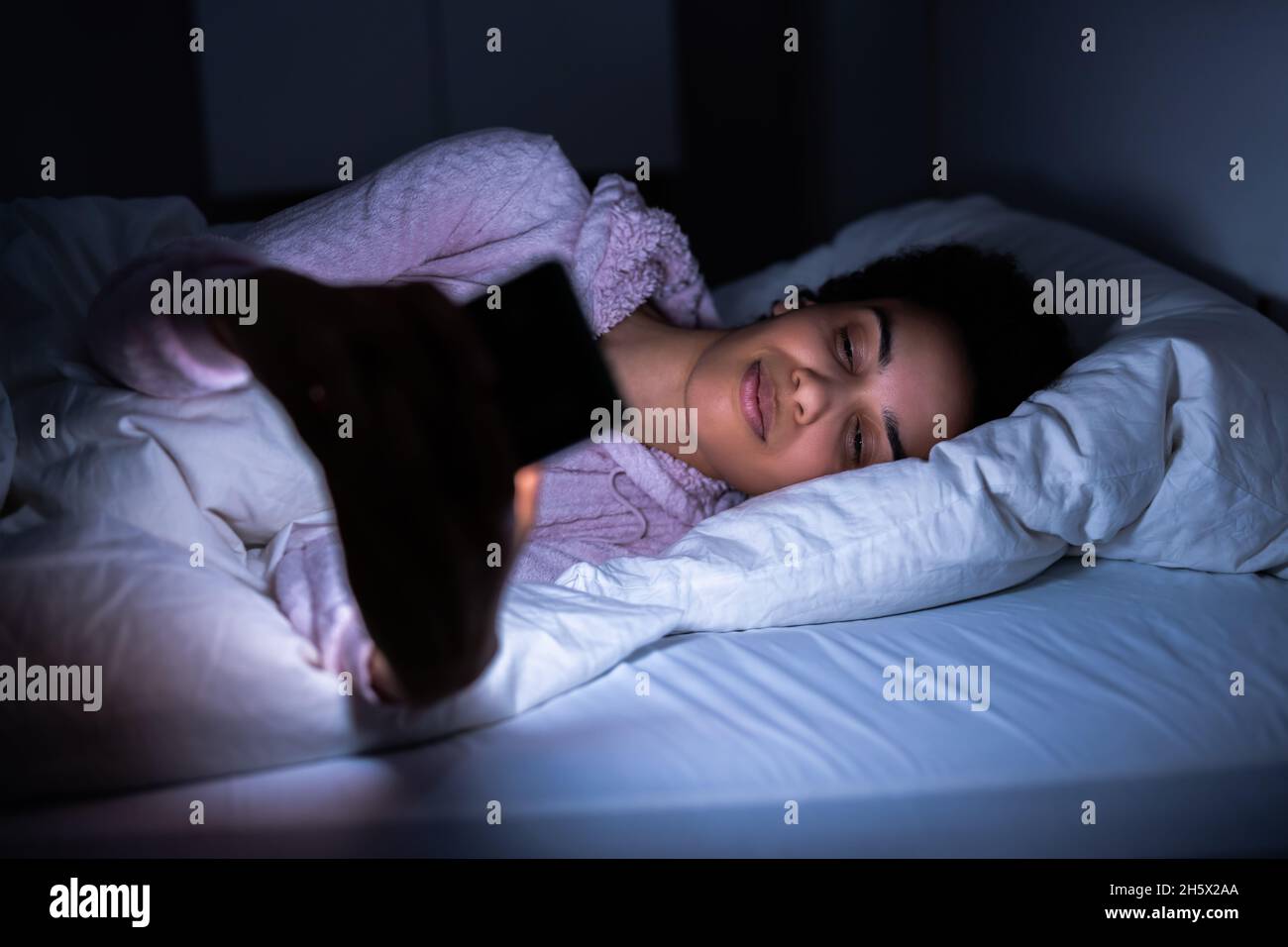 Vor Dem Schlafengehen Handy In Der Nacht Beobachten Stockfoto