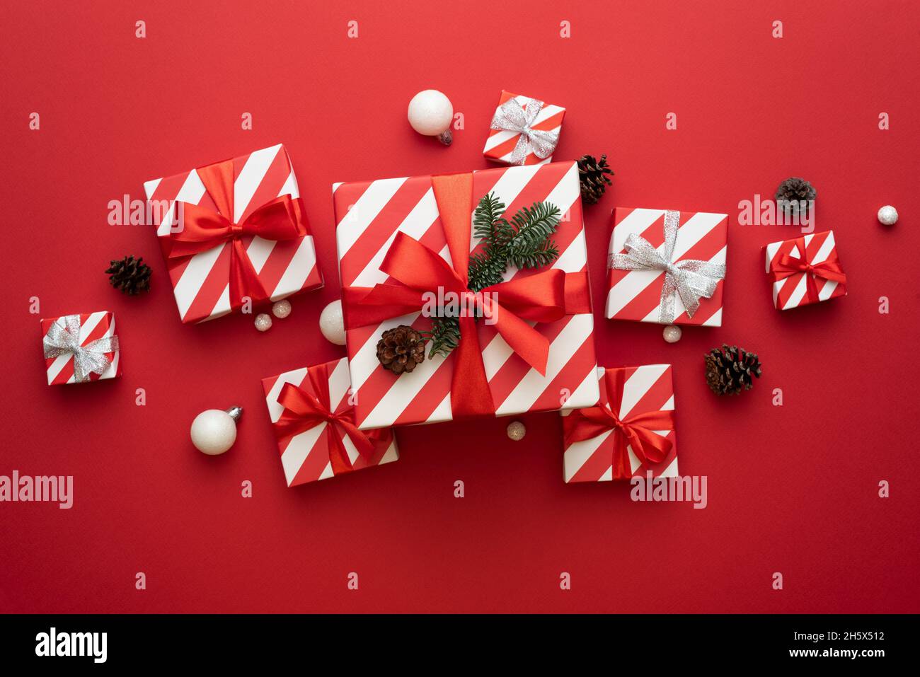 Weihnachtskarte mit Weihnachtsgeschenken auf rotem Hintergrund Stockfoto