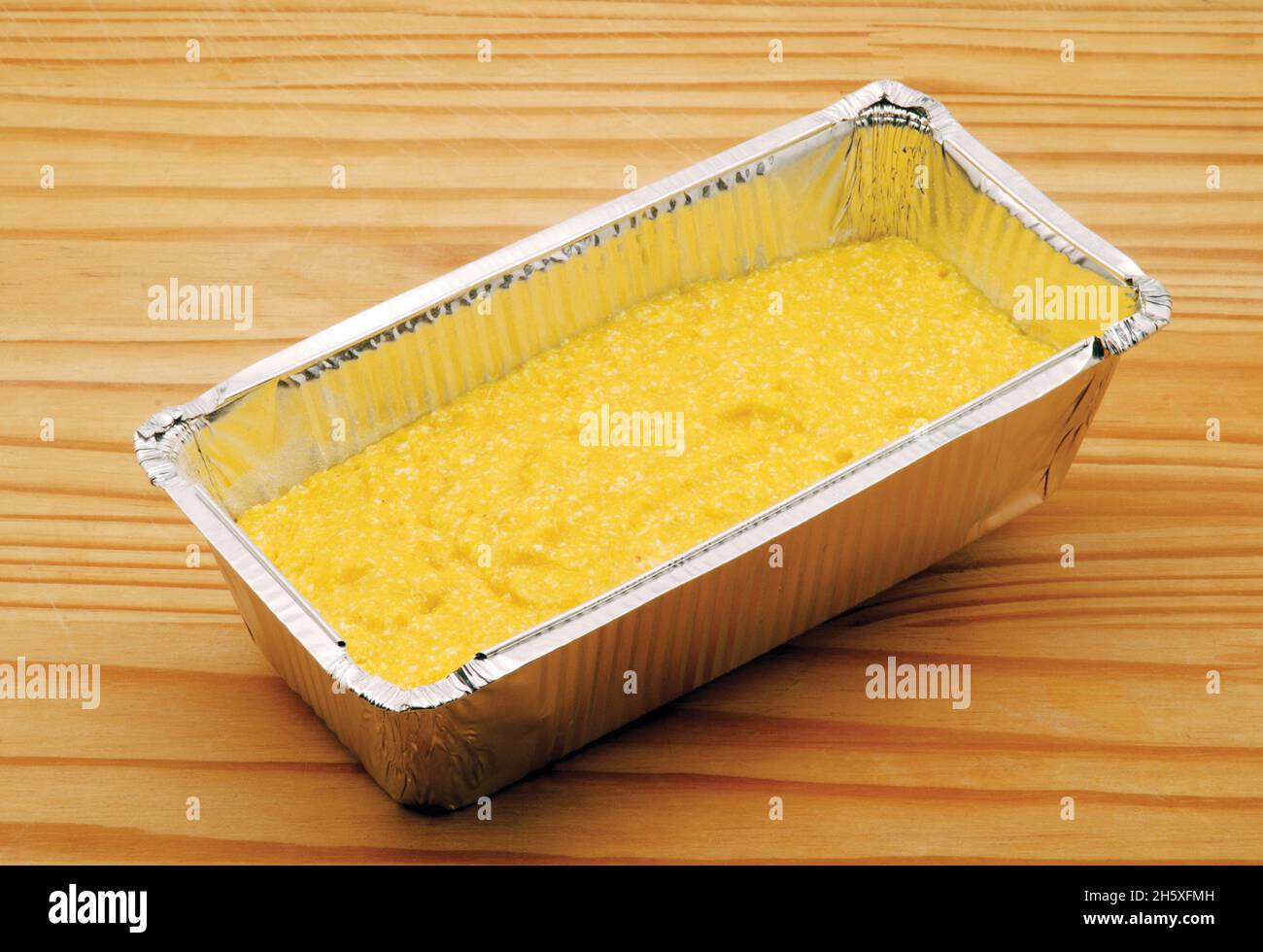 Plumcake mit Mais und Mandarine in einer geriebenen Aluminiumplatte Stockfoto