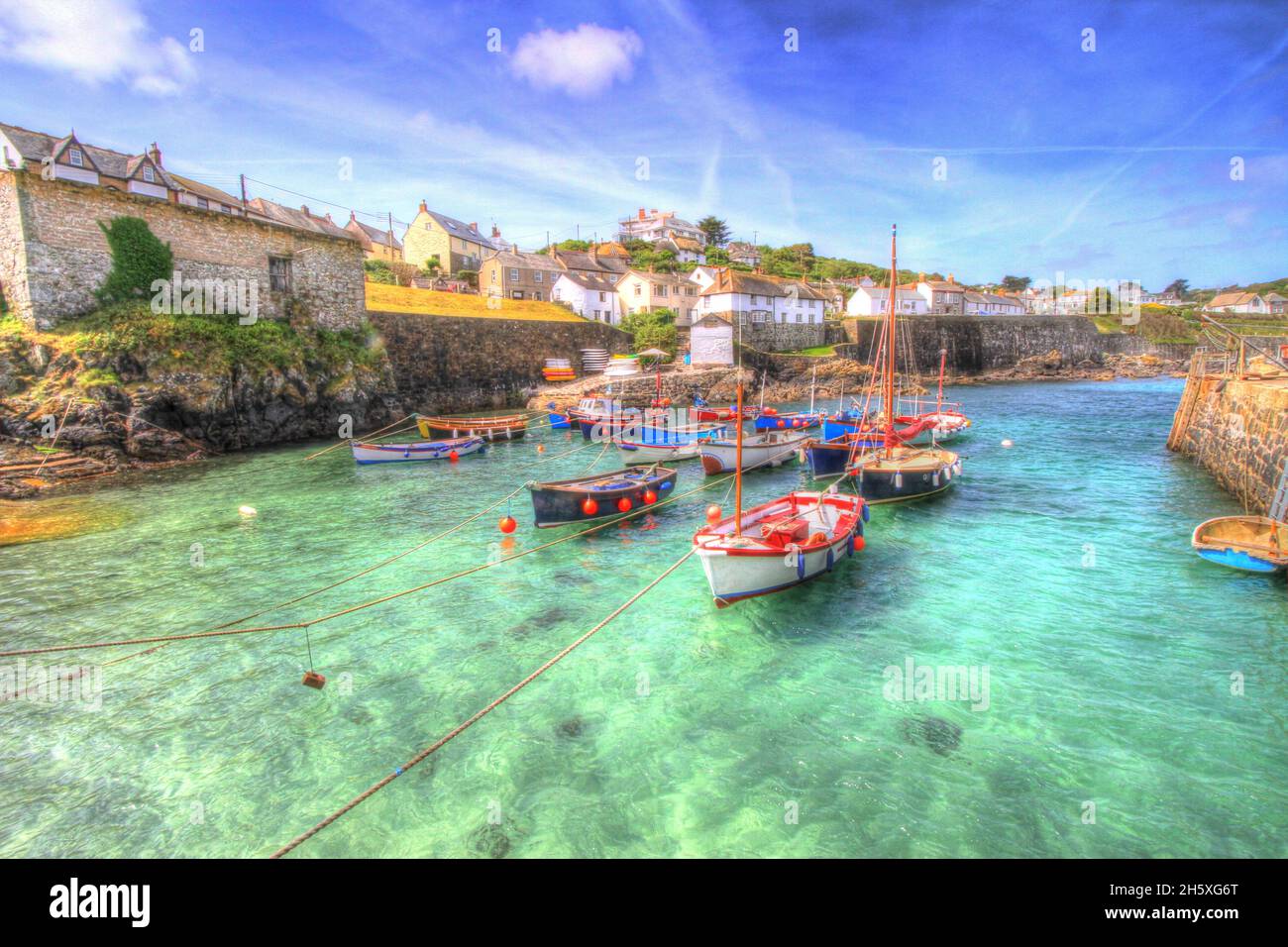 Klares blaues Meer Coverack Cornwall schöner kleiner Hafen farbenfrohes Küstenfischerdorf mit Booten Stockfoto