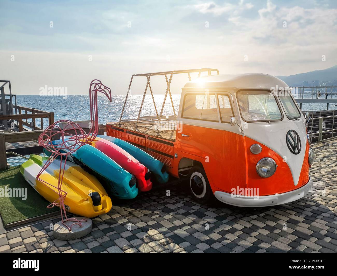 Jalta, Ukraine - Oktober 31,2021: Alte Retro-Vintage leuchtend orange weiß VW T1 bulli Wohnmobil-Bus angepasst als Kajak Bootsanhänger in der Nähe des Meeres geparkt Stockfoto