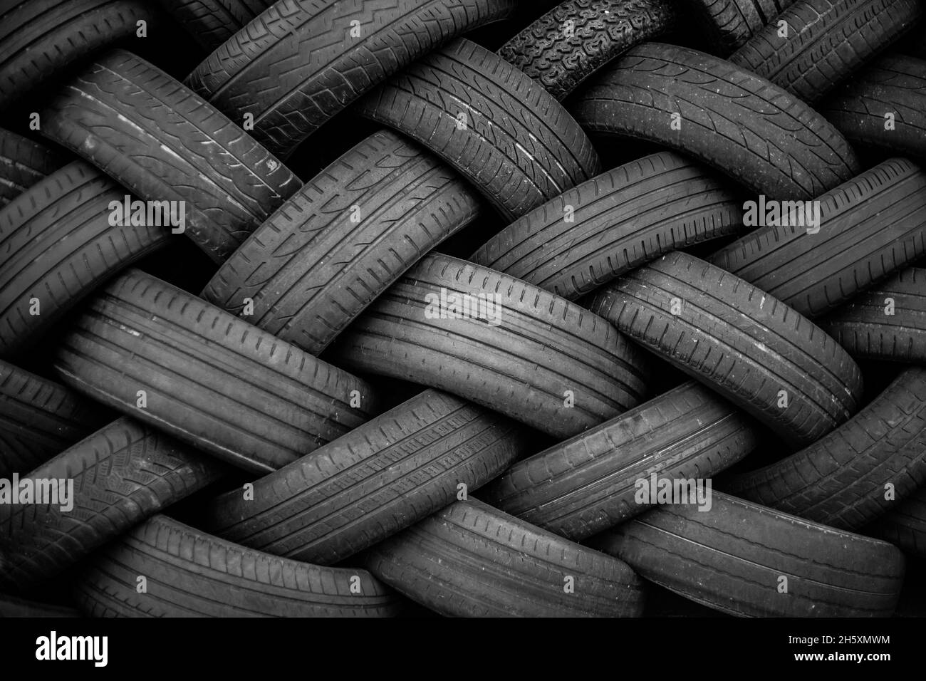 Alte Gebrauchtwagenreifen. Ein Haufen schwarzer Reifen, abstrakter Hintergrund. Stockfoto