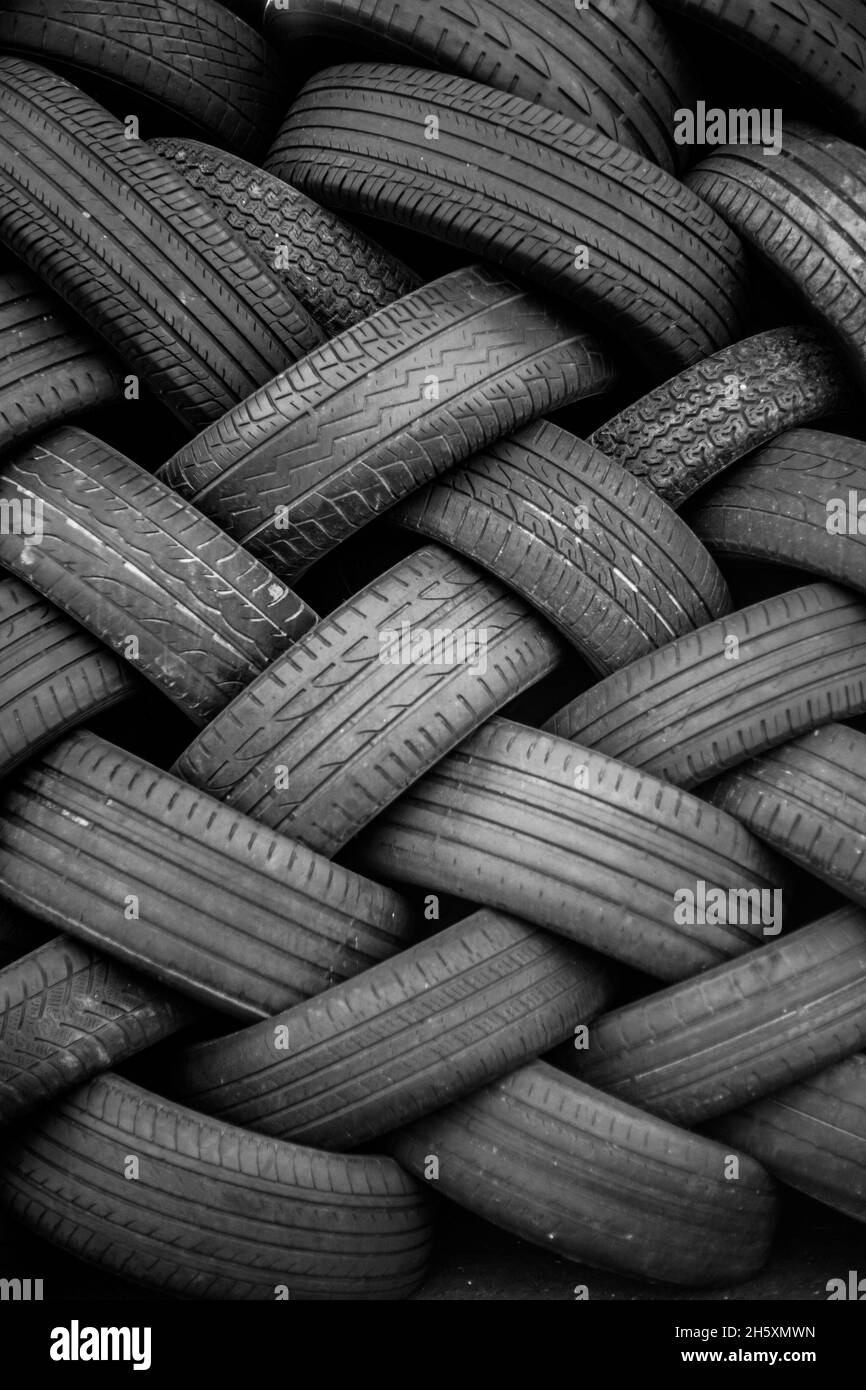 Alte Gebrauchtwagenreifen. Ein Haufen schwarzer Reifen, abstrakter Hintergrund. Stockfoto