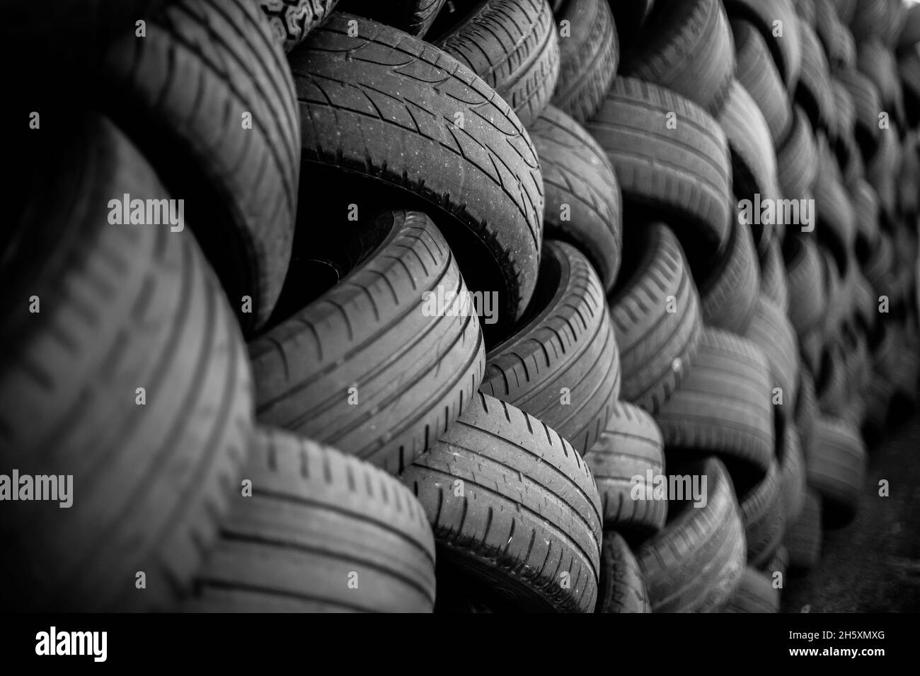 Alte Gebrauchtwagenreifen. Ein Haufen schwarzer Reifen, abstrakter Hintergrund. Stockfoto