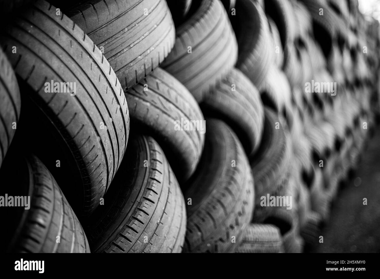 Alte Gebrauchtwagenreifen. Ein Haufen schwarzer Reifen, abstrakter Hintergrund. Stockfoto