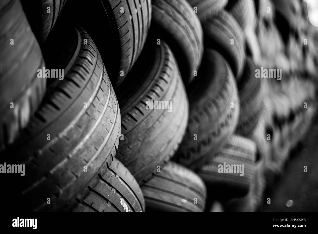 Alte Gebrauchtwagenreifen. Ein Haufen schwarzer Reifen, abstrakter Hintergrund. Stockfoto