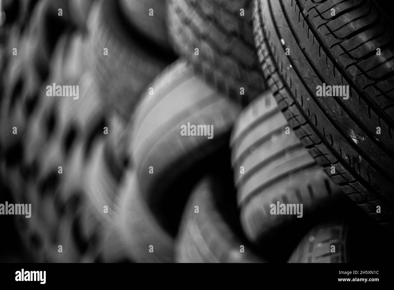 Alte Gebrauchtwagenreifen. Ein Haufen schwarzer Reifen, abstrakter Hintergrund. Stockfoto