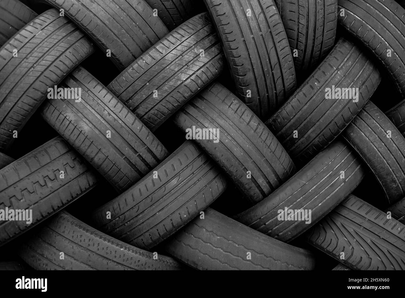 Alte Gebrauchtwagenreifen. Ein Haufen schwarzer Reifen, abstrakter Hintergrund. Stockfoto