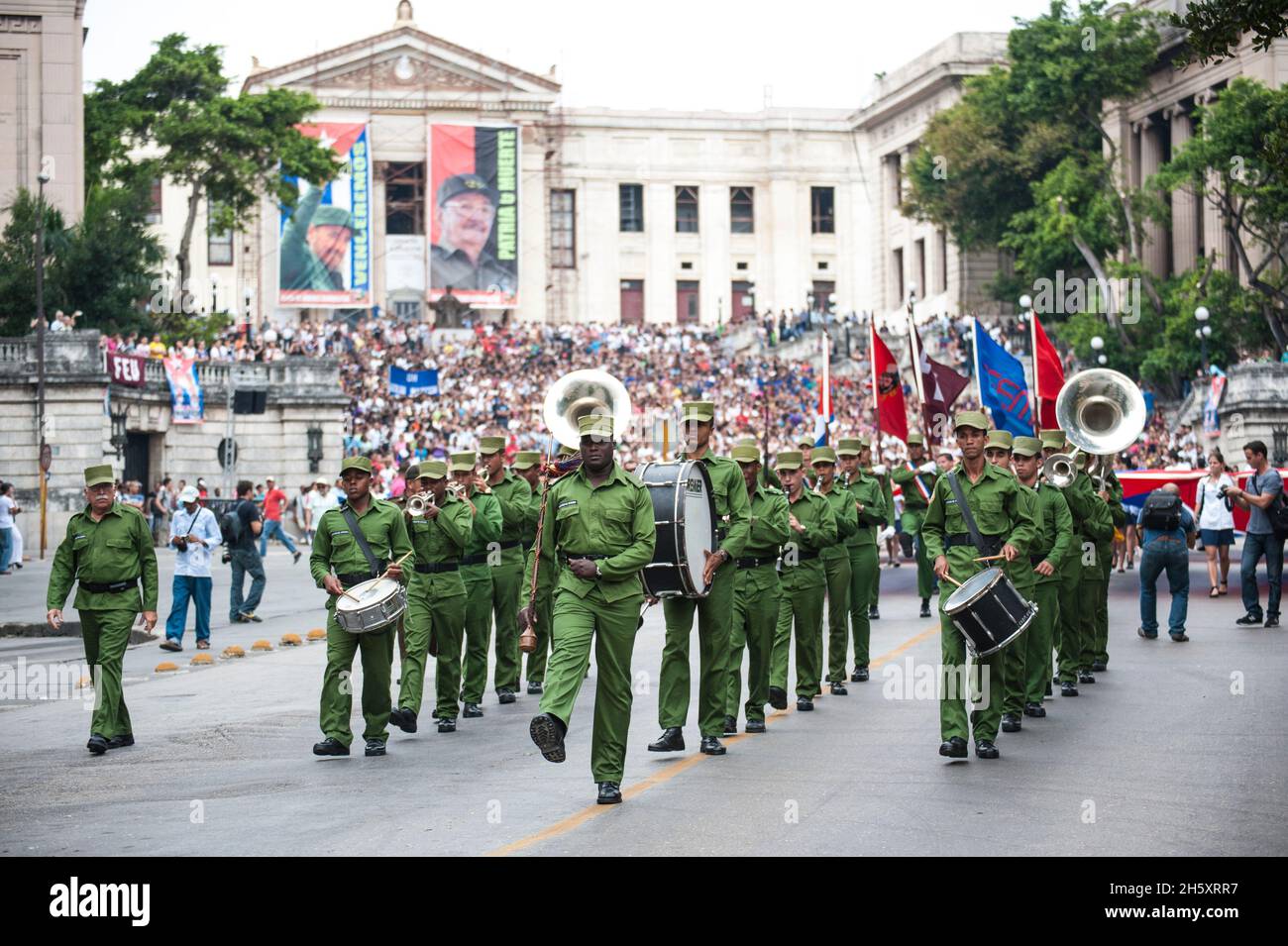 Cuban Drum Major spielt eine Band vor Fotos von Fidel Castro und Raul Castro an der Universität von Havanna, in Havanna, Kuba. Stockfoto