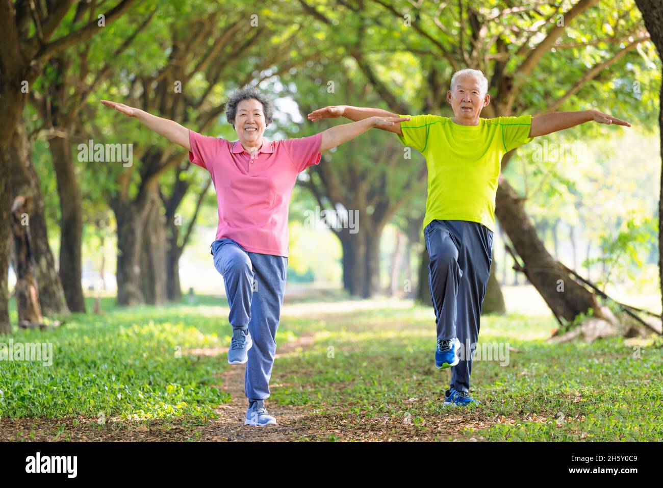 Glückliches Seniorenpaar, das im Park trainiert Stockfoto