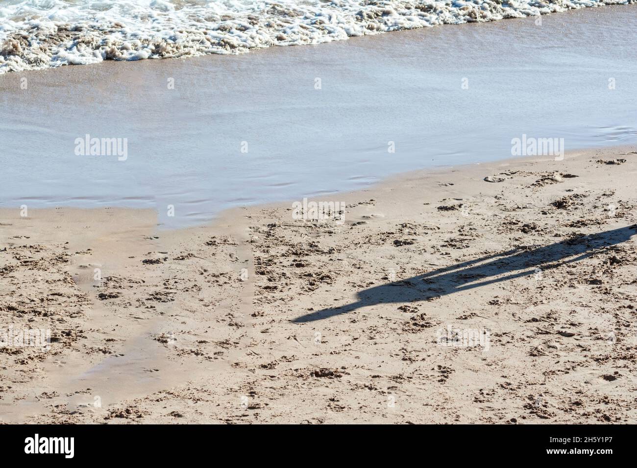 Schatten einer Person auf dem Sand des Strandes von ondina ein starker sonniger Tag. Salvador Bahia Brasilien. Stockfoto