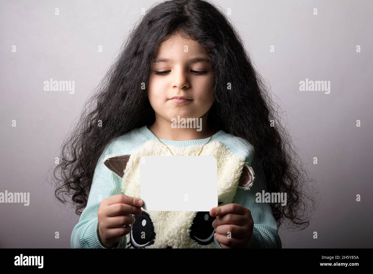 Kleines Mädchen Porträt hält eine Flash-Karte in der Hand, Vorschule Bildungsmaterial Lernobjekte. Flash-Karte Auswahlpfad enthalten. Stockfoto