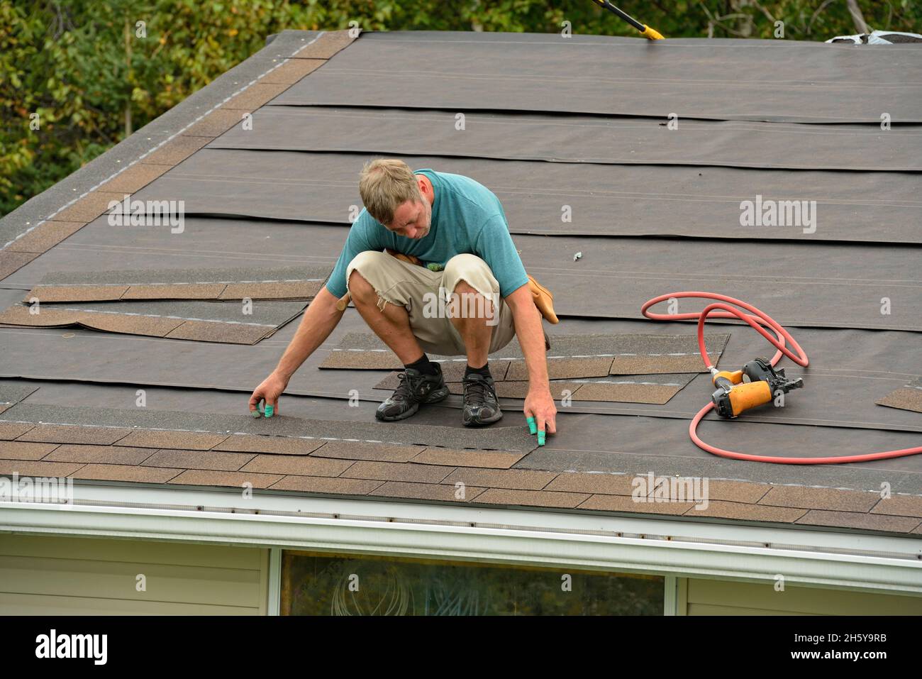 Installation von Schindeln auf einem Dach. Mit einem automatischen Schindelnagler, Greater Sudbury (Lively), Ontario, Kanada Stockfoto