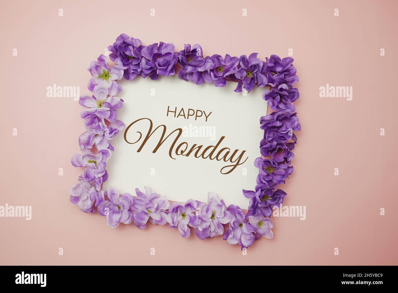 Happy Monday Karte Typografie Text mit Blumenstrauß auf rosa Hintergrund Stockfoto