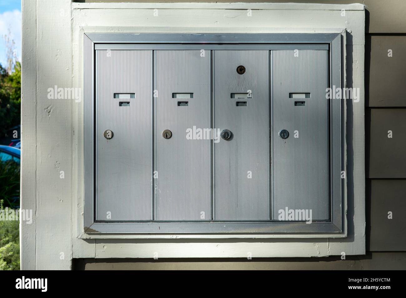 Verschlossene Türen des Briefkastens im Freien, der an der Wand der Wohnung, der Wohnung oder des Geschäfts montiert ist Stockfoto