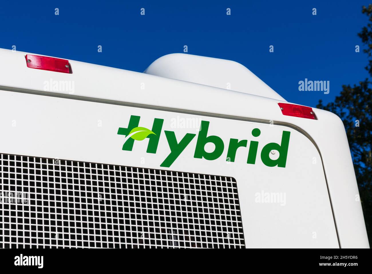 Grünes Hybrid-Zeichen auf dem Bus, der von einem ökologischen Elektromotor und einem Dieselmotor läuft. Stockfoto