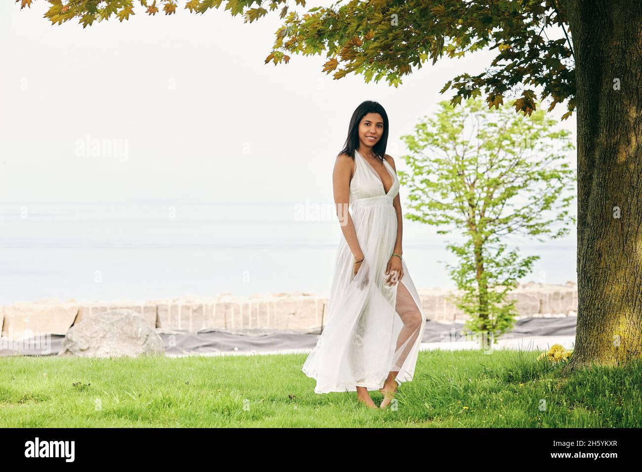 Ein erfrischender Tag: Die dunkelhäutige Latino-Frau genießt einen gemütlichen Spaziergang im Park Stockfoto